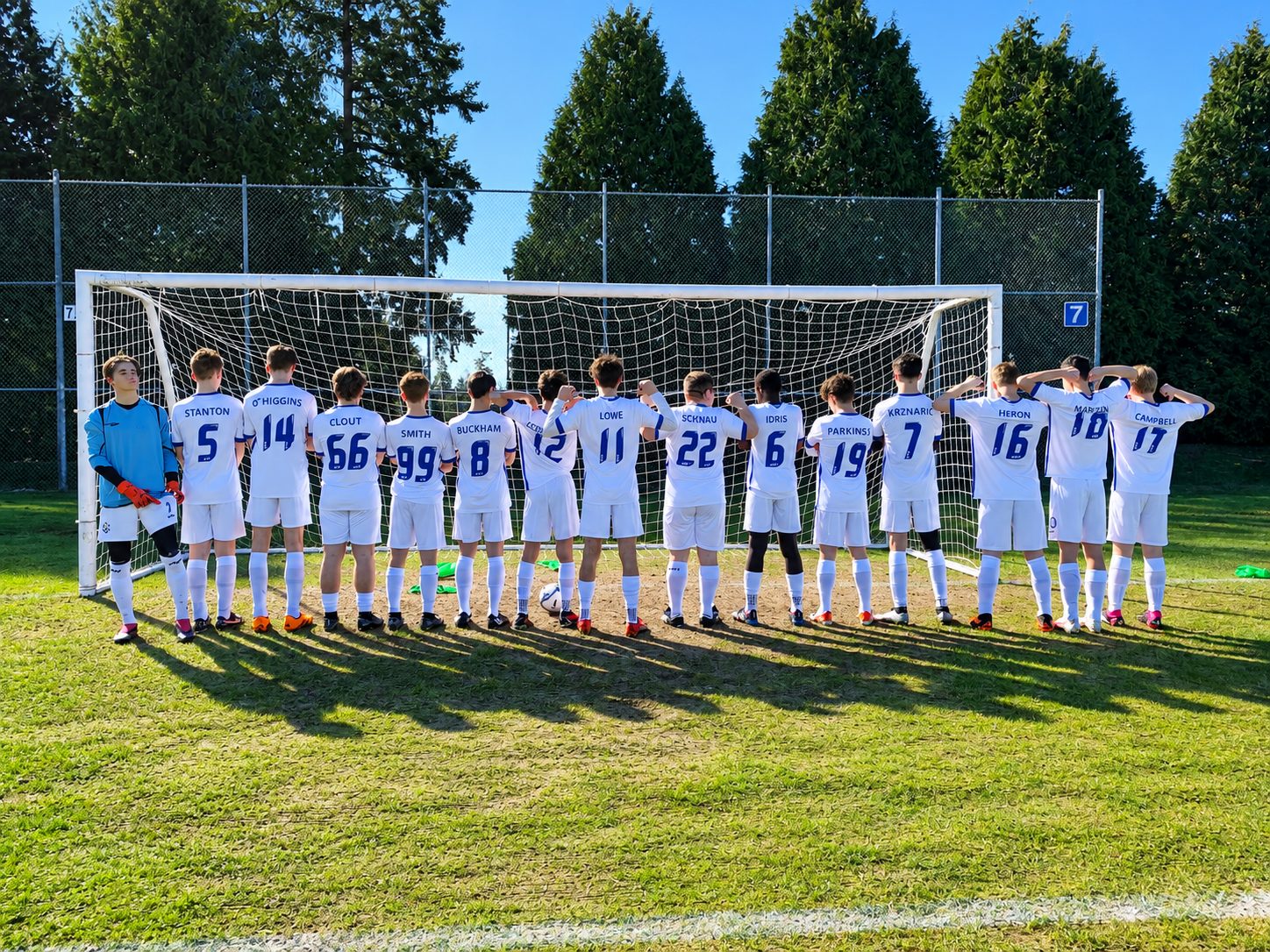 The JDF U17 boys soccer team lined up in front of the goal.